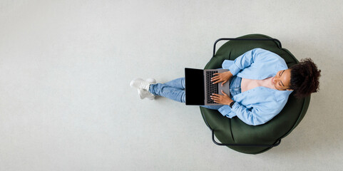 Portrait of smiling black woman using laptop at home