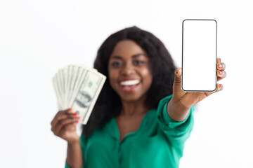 Cheerful black woman showing cellphone with empty screen and cash