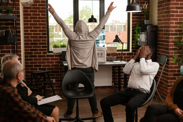 Man fooling around in front of people at group therapy session with psychiatrist. Funny person playing at aa meeting, trying to cure alcohol addiction and mental health problems.