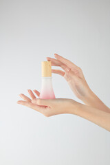 Hand model holding a cosmetic jar with a white background for cosmetic advertising