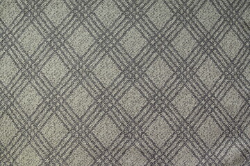 The texture of gray plaid suit fabric is close-up with diagonal threads for a traditional business background in neutral tones. Checkered pattern, diagonal fabric background, grunge material.