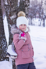 Cute little girl is going skate outdoors.