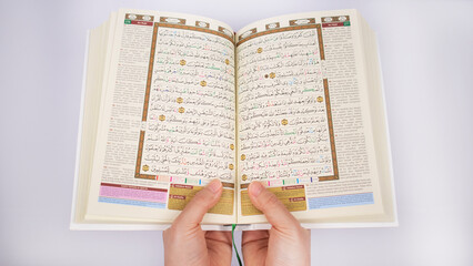hands holding al-quran in a white background