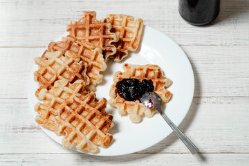 Belgian cottage cheese waffles with berry jam on a white plate.