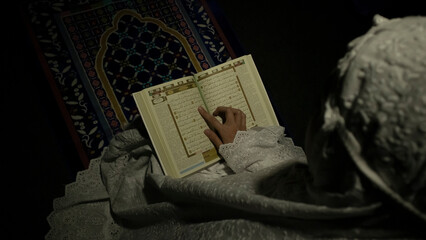 muslim girl readng quran in the dark room