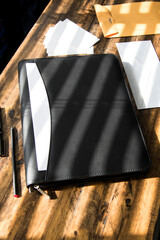 Black leather business padfolio portfolio folder on desk