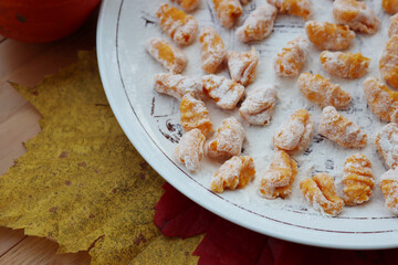 Top view of handmade italian traditional  pumpkin Gnocchi  ready for cooking on a plate on wooden table