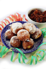 Traditional italian Fritters called Frittelle on white with Carnival decorations. Fritters with raisins