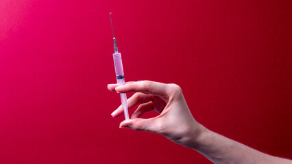 female hand holding a medical syringe