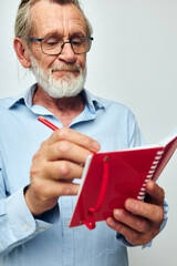 Senior grey-haired man writes down emotions in a notebook unaltered