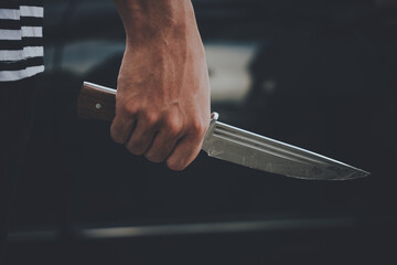 dangerous man criminal holding knife as a weapon in car park, Crime against women.