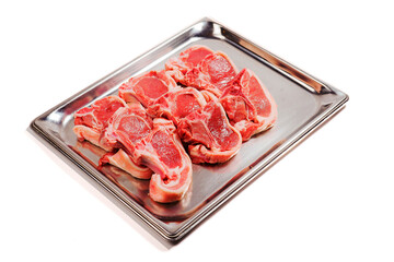 Nine fresh lamb chops on a metal tray. Meat industry product. Butcher craft. Fresh meat on a bone uncooked. White background.