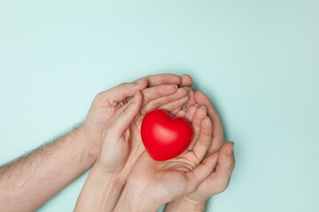 Man and woman hands holding red heart, health care, donate and family insurance concept, world heart day.