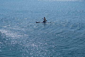 A young sports man with a child sails on a sup in the sea. Healthy lifestyle concept