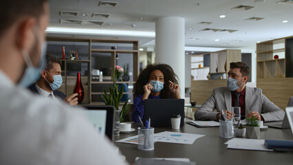 Multiethnic office workers discuss financial plan. Business group in facial mask