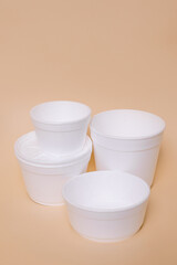 Disposable plastic containers for food on a peach background. Concept of using eco utensils.