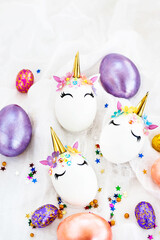 Easter eggs in the form of a unicorn on white background, copy space for text, top view, flat lay
