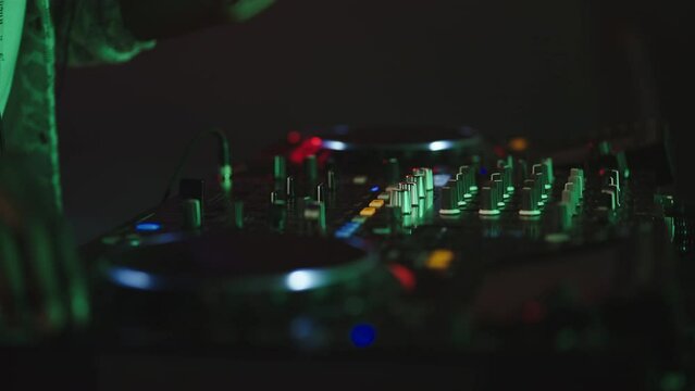 DJ playing in music club. Close-up of hands and mixing console. Nightlife, modern music and entertainment concept.