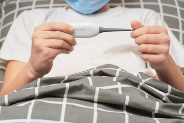 child looks at the thermometer. close-up of a child's hands holding a thermometer