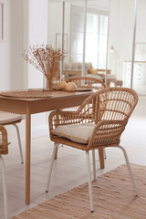 Dining room interior with wooden table and wicker chairs