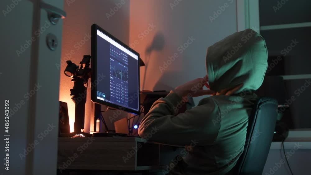Poster daytrader nerd follows crypto currency market live on computer screen in dark room, low angle side v