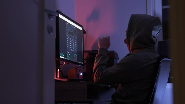 Man in hoodie trading crypto at home