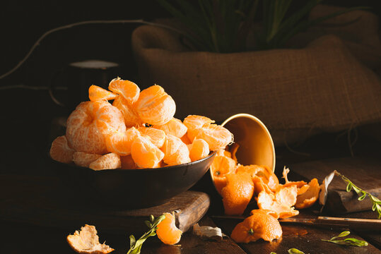 Juicy tangerines falling on dark backgorund