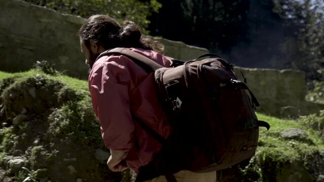 Young beard man in the jungle of deodar, willow, pine and robinia in manali. Young man trekking for joginifalls, Himachal Pradesh