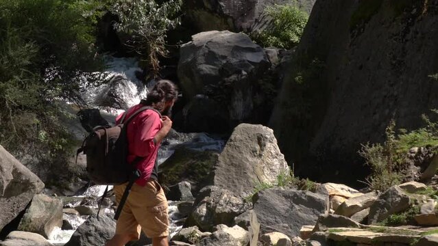 Young beard man in the jungle of deodar, willow, pine and robinia in manali. Young man trekking for joginifalls, Himachal Pradesh