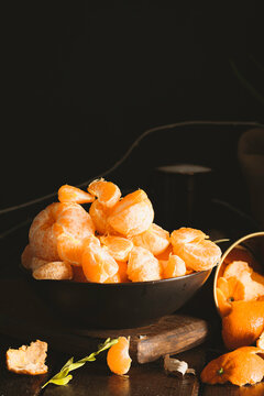Juicy tangerines falling on dark backgorund