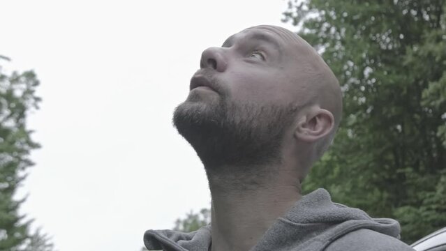 Close up of Caucasian man talking alone with mother nature looking up to the sky asking praying gods divinity