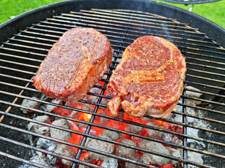 Grilling beef steaks on open grill grate. Photo of meat or barbeque cooking process.