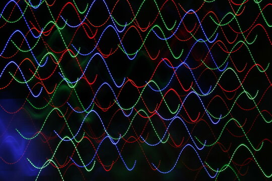 Luz de ne&ograve;n en ondas multicolor simula el viaje de la luz en el espacio, forma un bello dise&ntilde;o abstracto con fondo negro