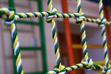 Beautiful knots of yellow-green ropes. Blurred background. Close-up.