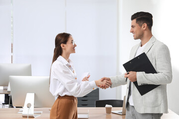 Employee shaking hands with intern in office - obrazy, fototapety, plakaty