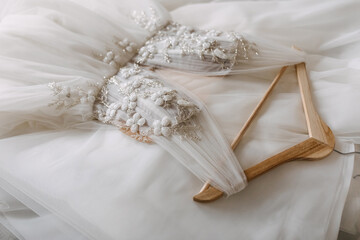 Closeup of a handmade wedding dress with flower and crystals embroidery.