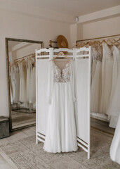 Bohemian style wedding dress hanging at a bridal showroom.