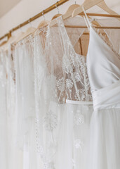 Closeup of wedding dresses hanging at a bridal showroom. New collection of bohemian style wedding gowns.