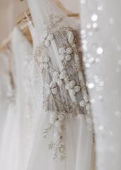 Closeup of wedding dresses hanging at a bridal showroom. 