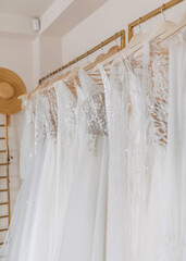Wedding dresses hanging at a bridal showroom. New collection of bohemian style wedding gowns.
