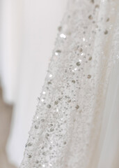 Closeup of white fabric with sparkly sequins.