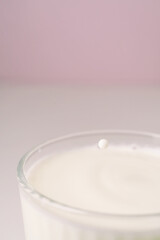 Milk drips into a transparent faceted glass.