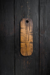 Aged wood cutting board, top view flat lay , with copy space for text or your product, on black wooden table background