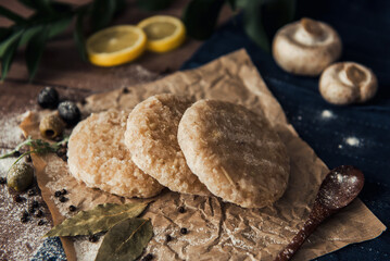 Raw fish cutlets on a wooden plate