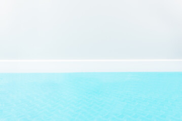 Blue yoga mat against a gray wall. Horizontal orientation, copy space. Soft focus.