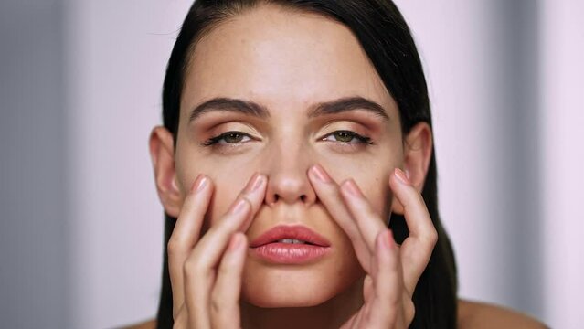 Beautiful girl touches her nose and thinks about rhinoplasty. Dream of plastic surgery