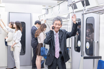 電車内で通話をするビジネスマン