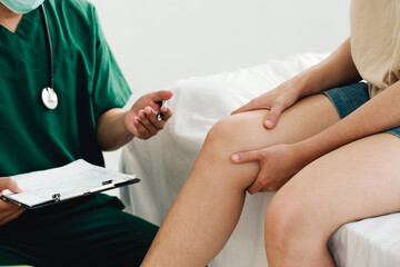 The patient is consulting a therapist and explaining with injured leg or knee after the accident and explain to her the diagnosis of the problem in clinic, Sport exercise injuries.