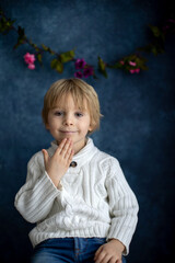 Cute little toddler boy, showing gesture in sign language on blue background, isolated image, child...