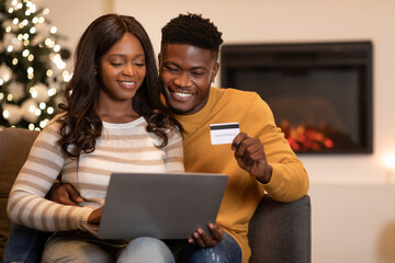 Spouses Shopping Via Laptop And Credit Card On Christmas Indoors